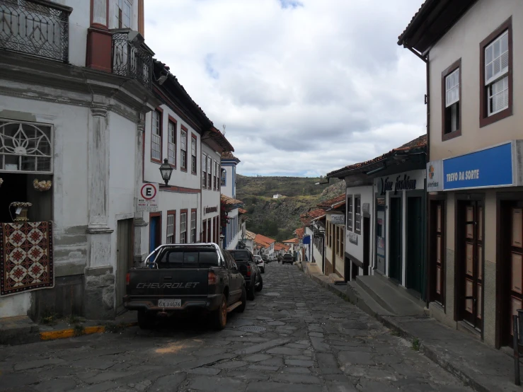 cars parked along the side of small, cobblestone roads