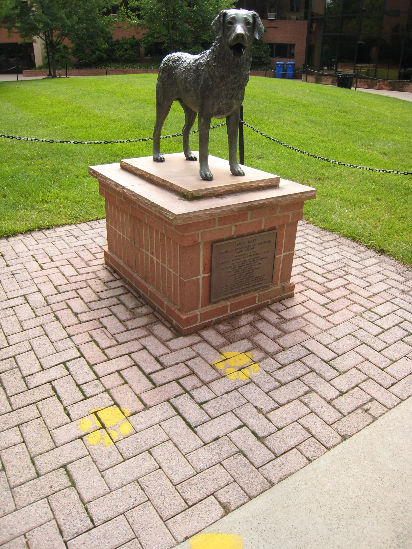 a statue of a dog is sitting on a block outside