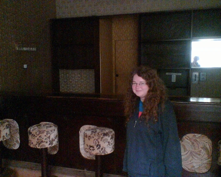 a lady is posing for the camera in front of old furniture