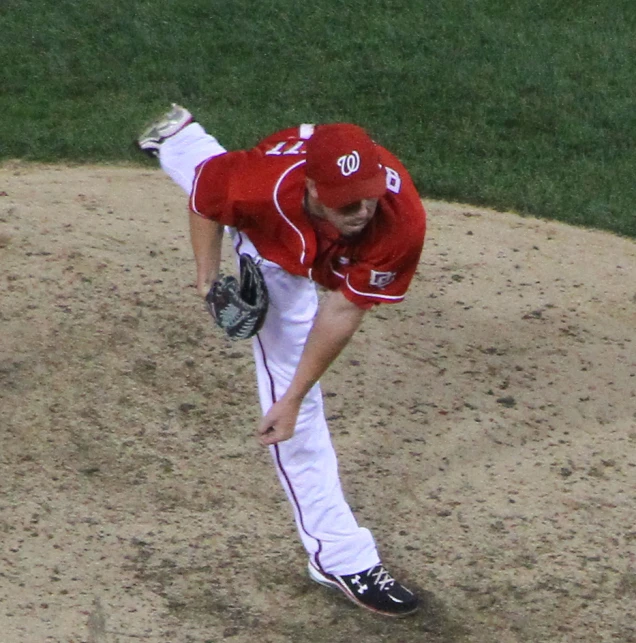 a baseball player throws a pitch from the mound