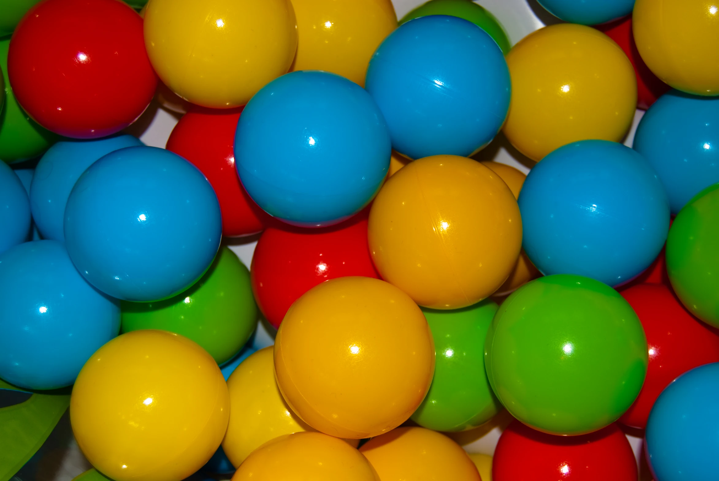 a bunch of balls are in color yellow, blue, red, green and orange