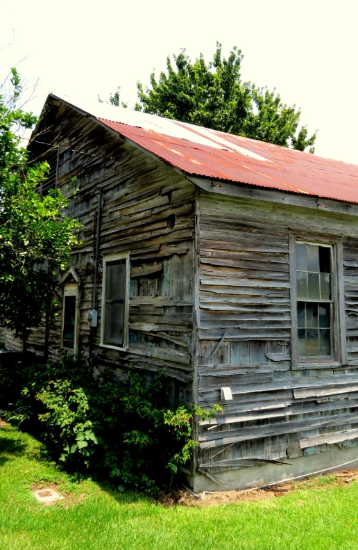 a small wooden house in the middle of an open field