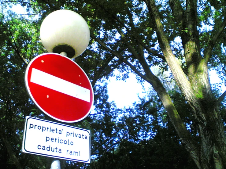 a red sign with white strips and an english one underneath