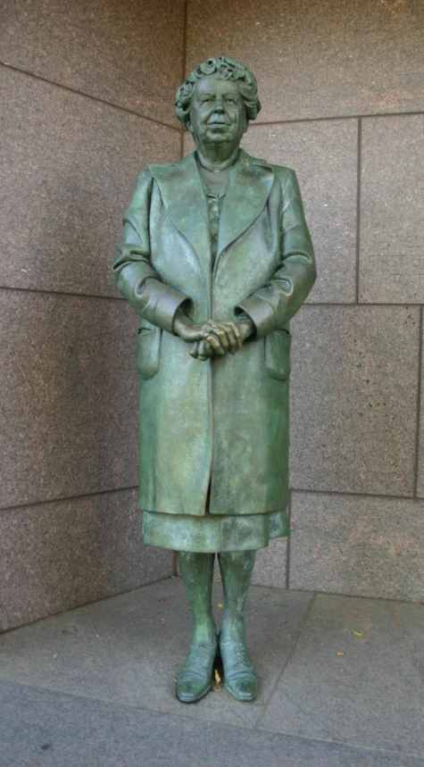 there is a green sculpture of a woman in a suit