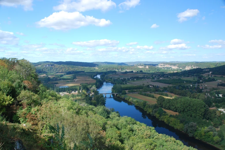 a view of a river running through green countrysides