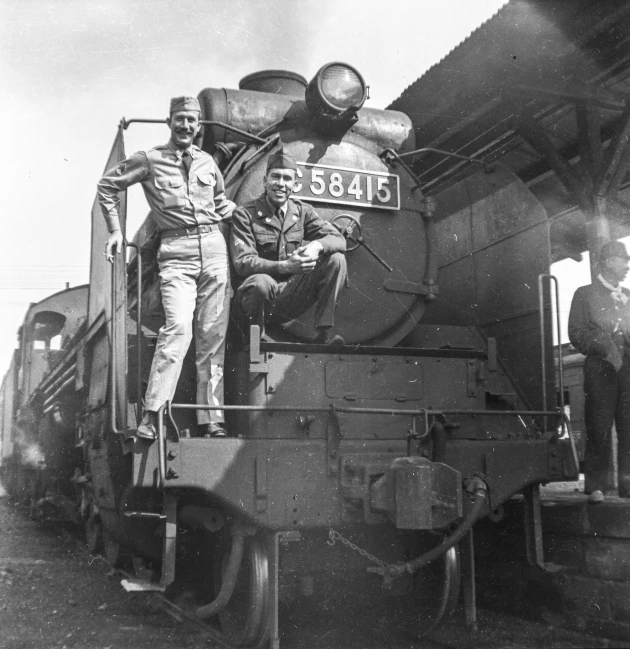 a couple of men sitting on the front of a train