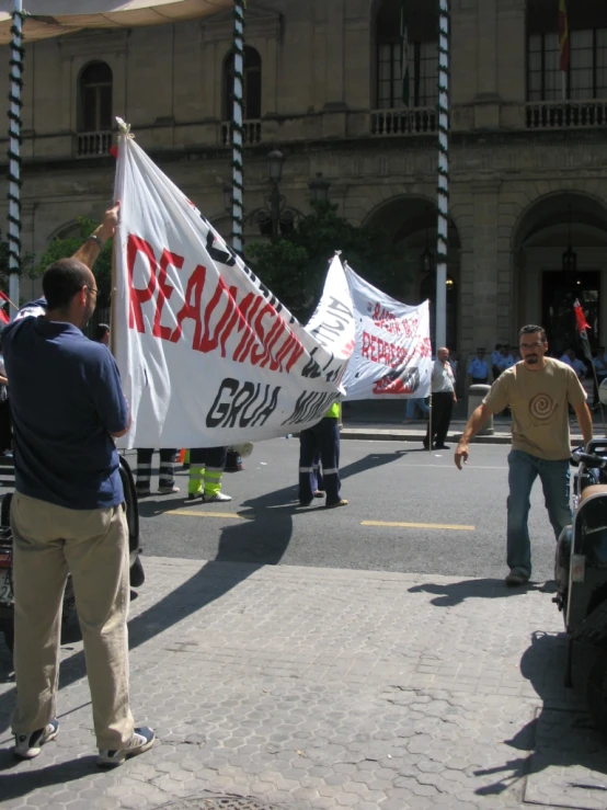 men standing on the street with signs and other people