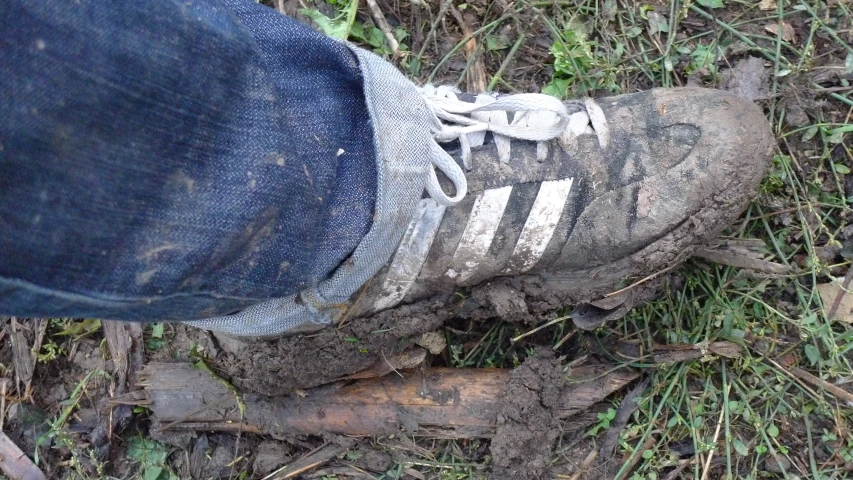 the bottom of a worn out shoe on grass and dirt