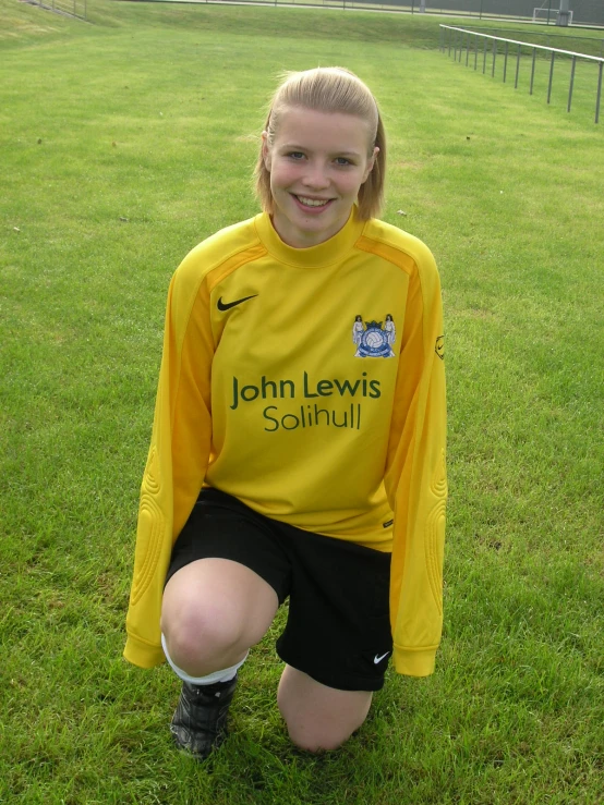 the young woman is smiling in a yellow uniform