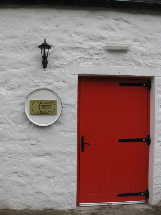 a red door and light next to a house