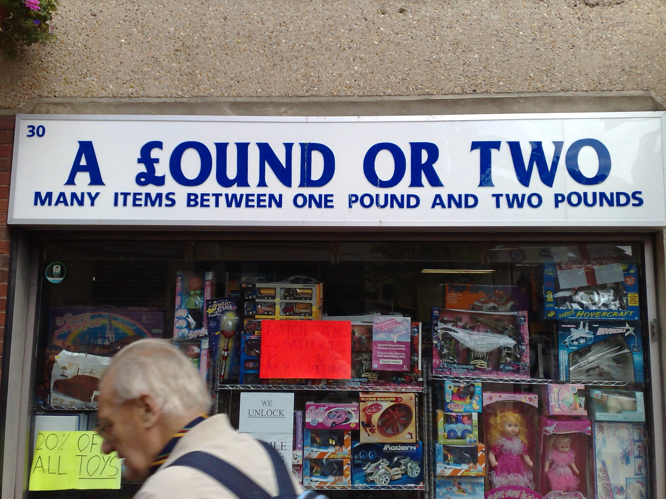 man walking past an advertit in a shop