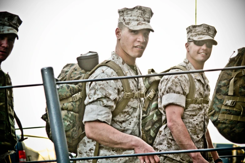 two soldiers holding onto a metal railing together