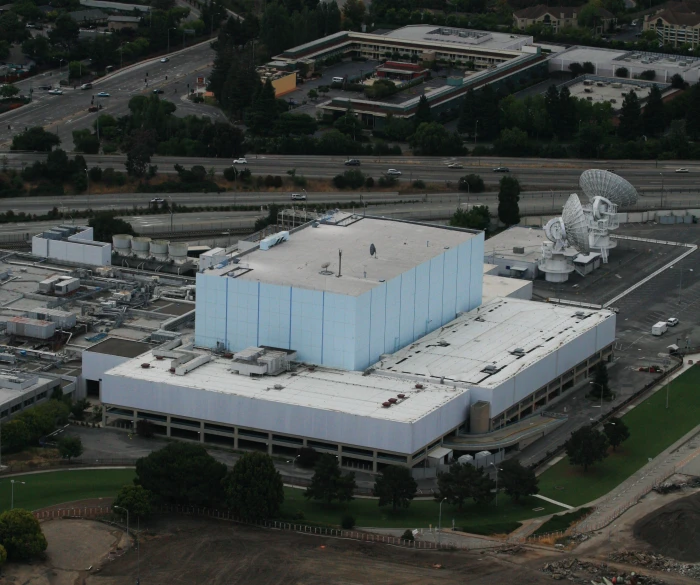 an aerial view of a building with satellite antennas on top