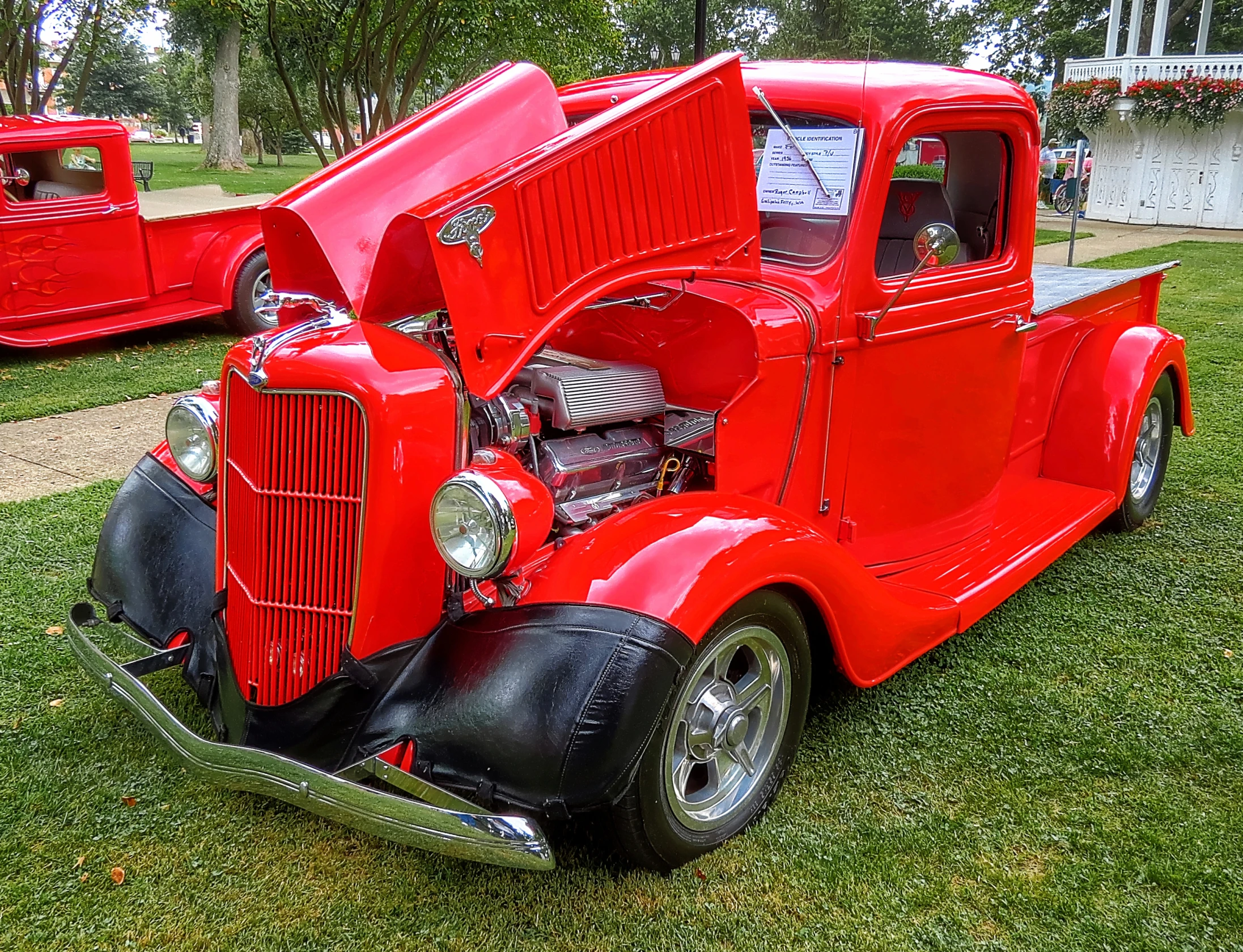 a very large and shiny red truck with its hood open