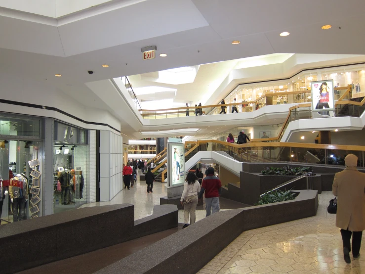 an indoor mall with escalators and many people