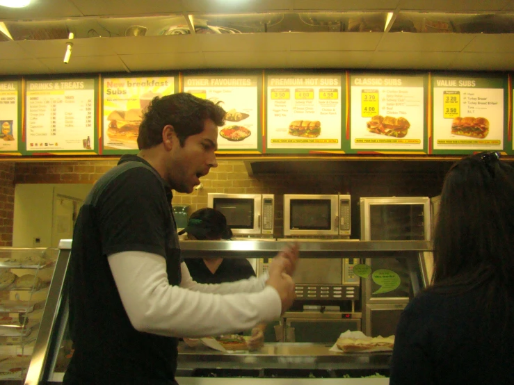 a man preparing food in front of a customer
