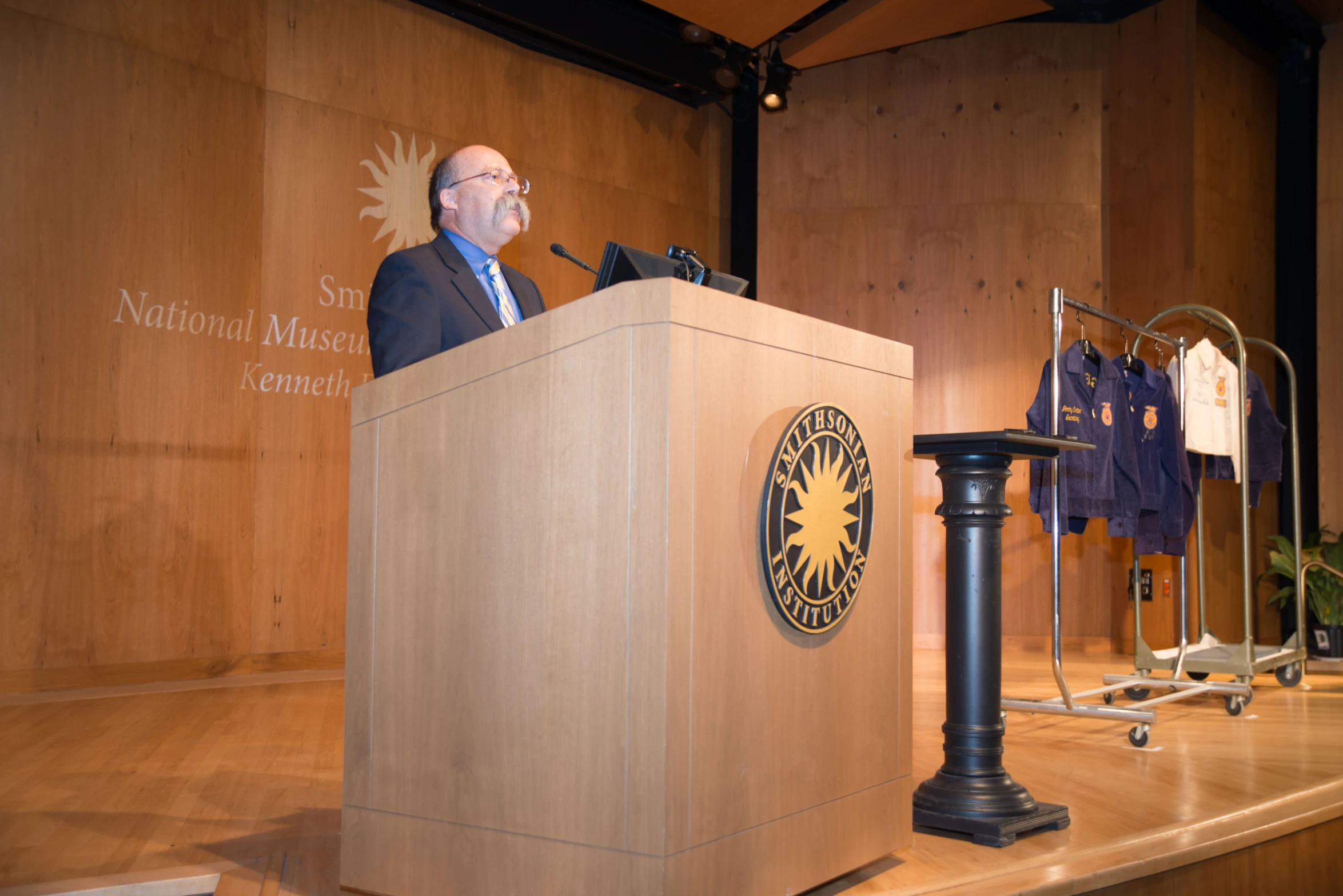 the speaker is standing at a podium with an microphone