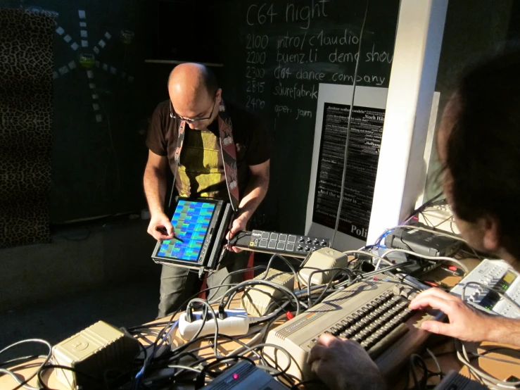 two men looking at computer equipment on desk