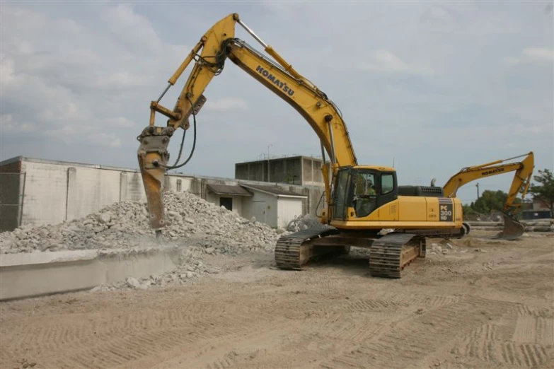 a large yellow excavator is parked outside in the dirt