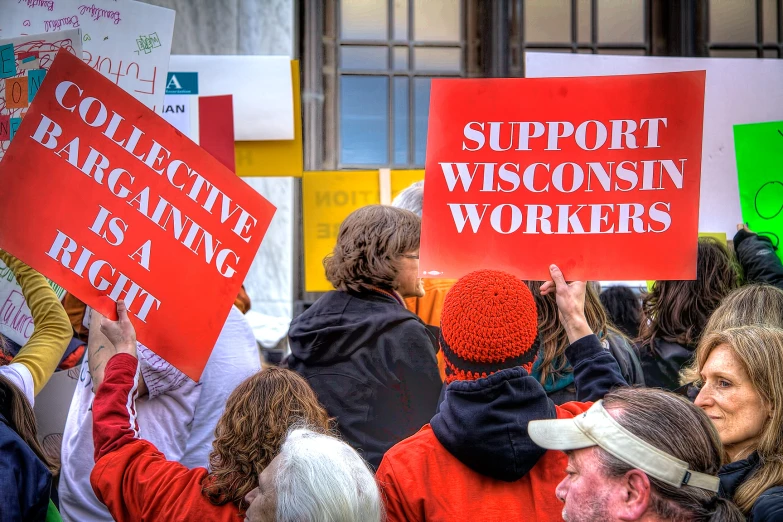 a crowd of people holding signs saying support wisconsin workers