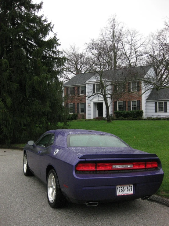 a purple sports car parked in front of a house