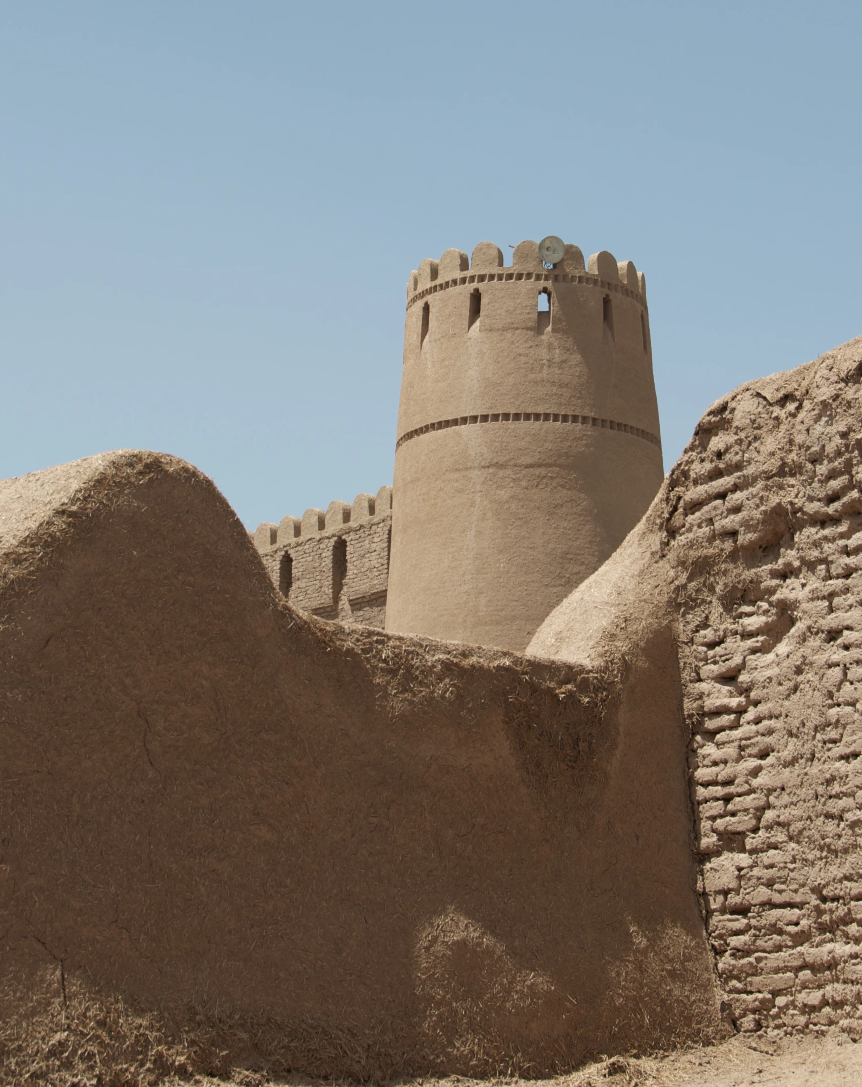 a small brown castle near a desert building