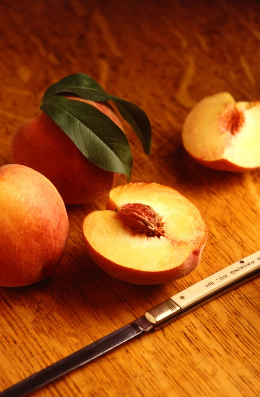 two peaches on a table next to a measuring cup