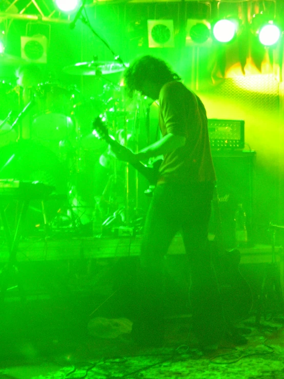 a band with lights on and a man playing a guitar