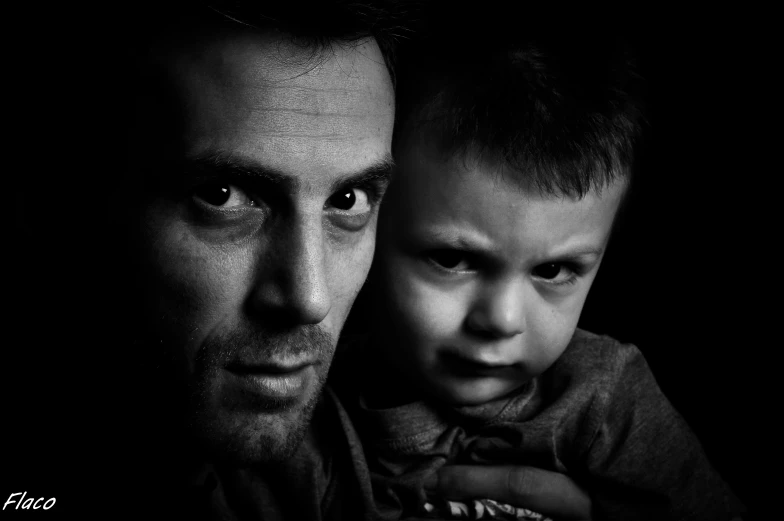 a little boy with his father and his hand around his neck