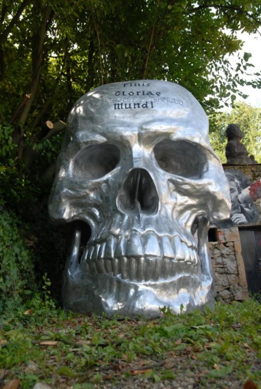 a small silver skull statue sits near a park