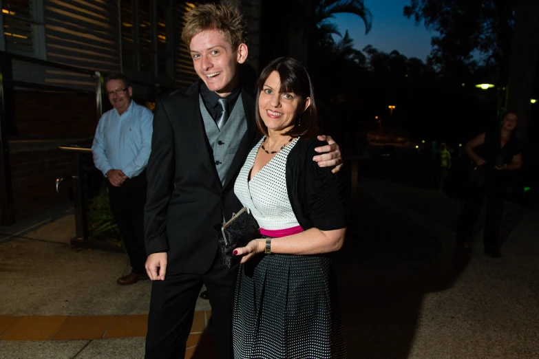 a man and woman standing on the sidewalk at night