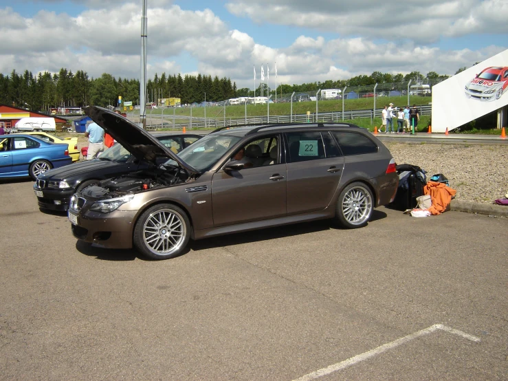 a car with its hood open next to a car park