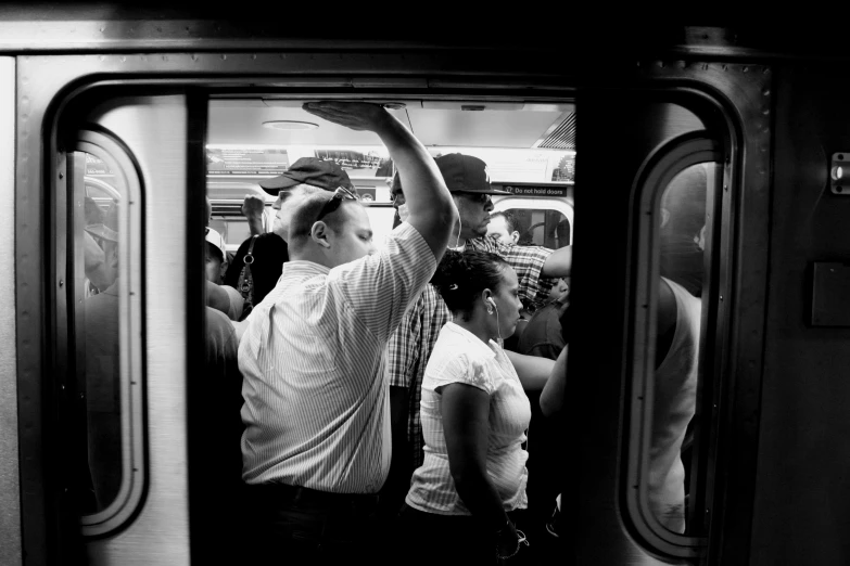 the people are standing next to each other in the subway