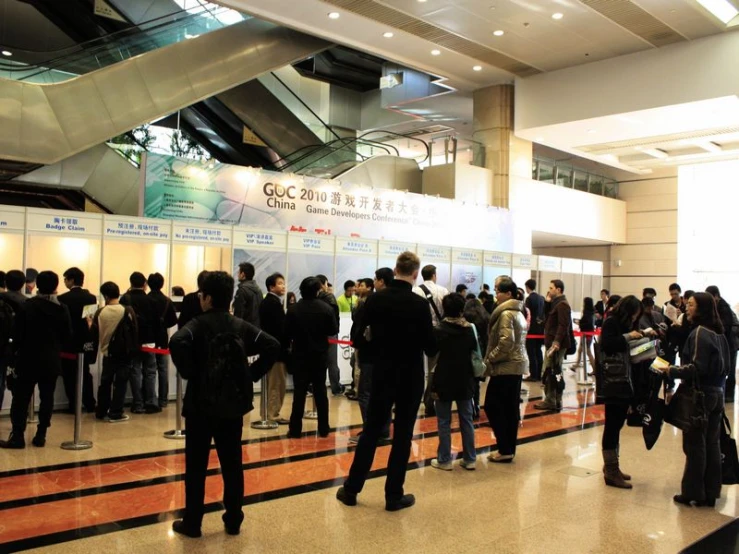 many people standing in the hall at a conference