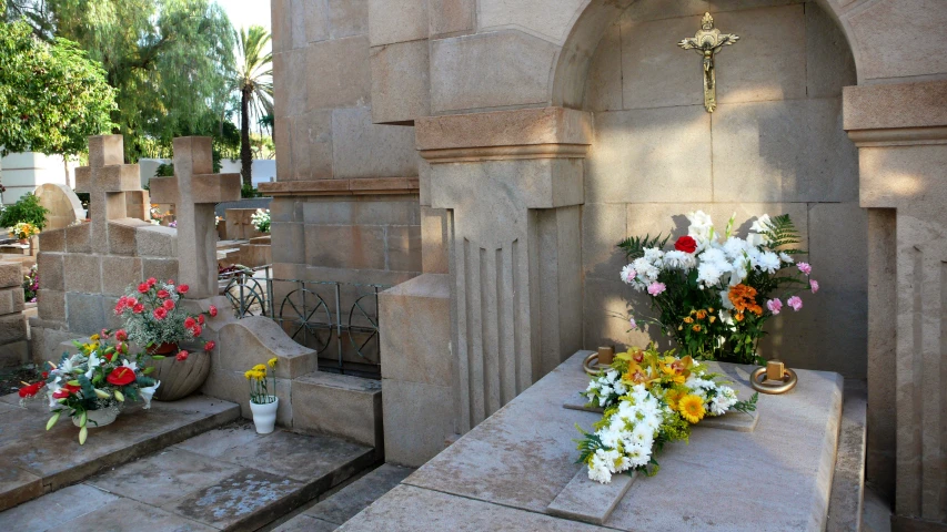 a grave with flowers on it and a cross above it