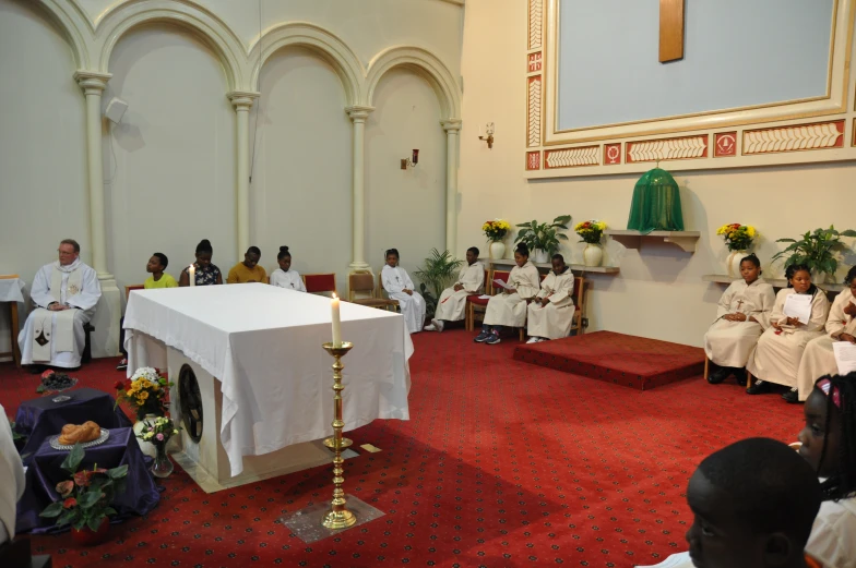 several people sitting in white chairs in a church