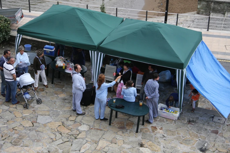 people standing around a tent with tents on the side of the road