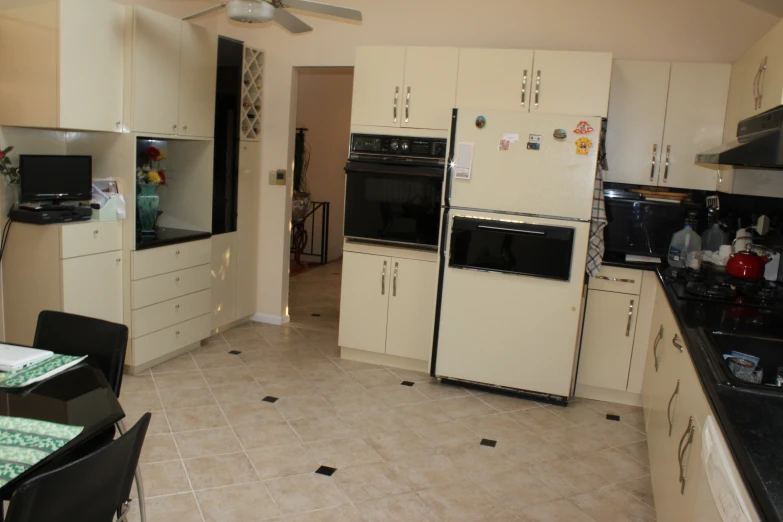 a kitchen with white cabinets, floor tile and a center island