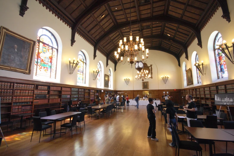 the large room features vaulted ceilings, wood floors and chandeliers