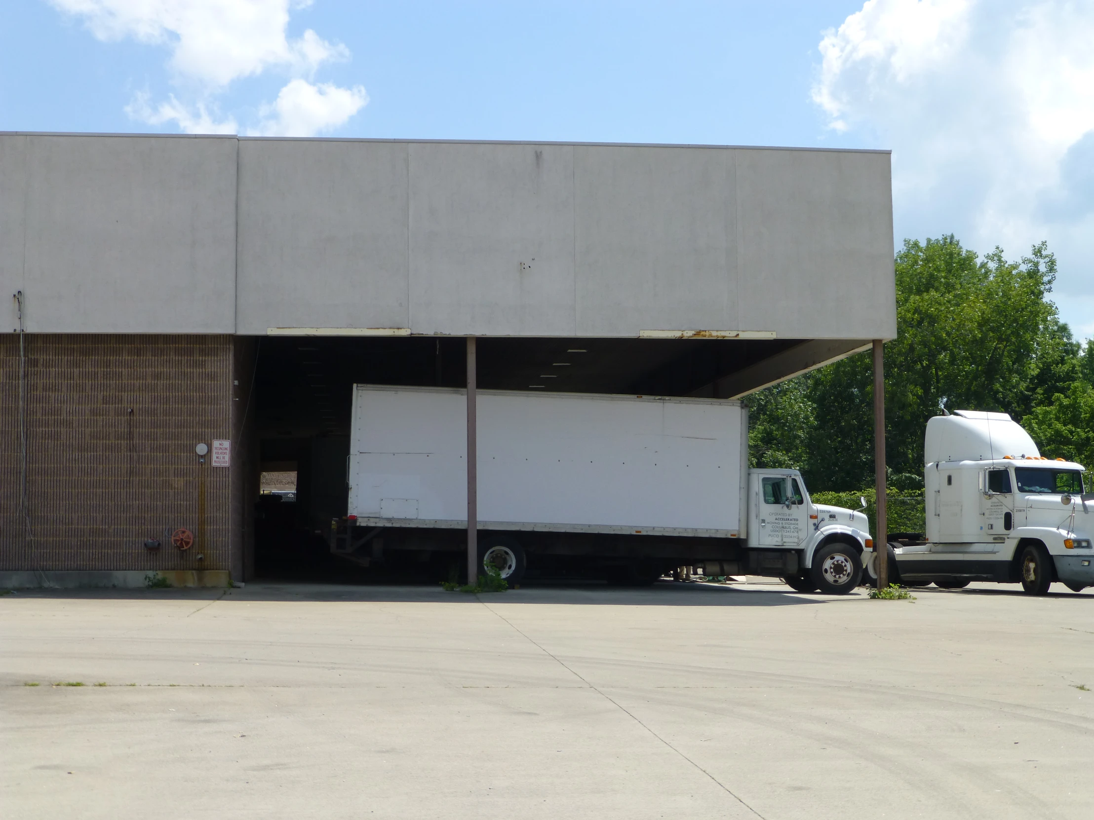 a large white truck parked in front of a cement building