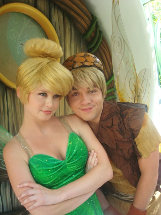 the couple is dressed as tinkerbells and smiling at the camera