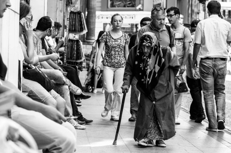 black and white po of a line of people walking by a building