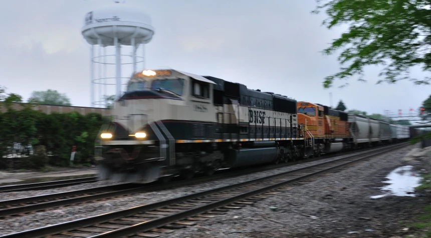 an orange and white train is rounding a curve