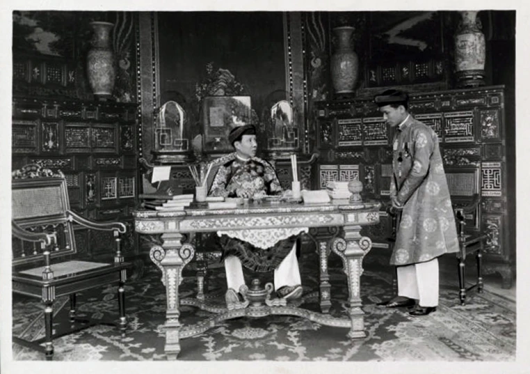 two people are standing near a table with books