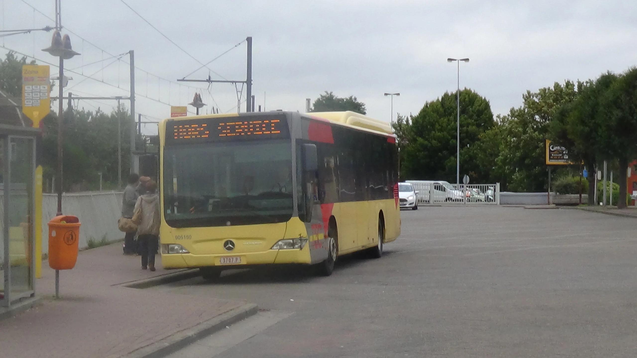 a city bus is parked at a bus stop