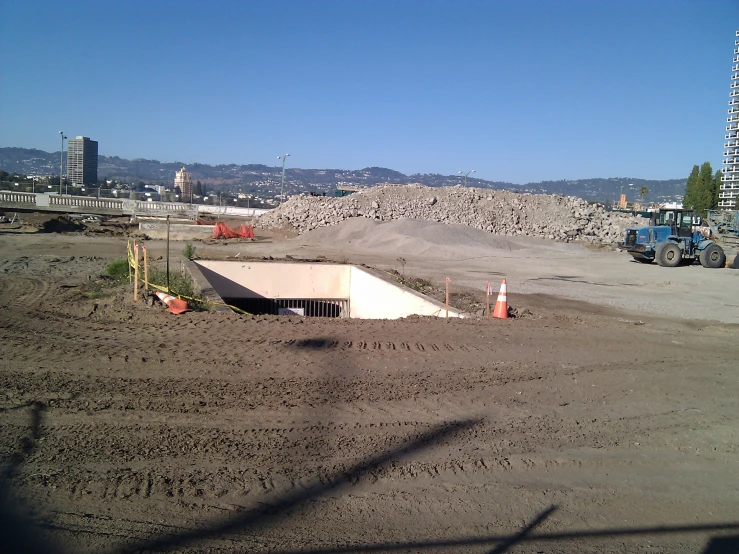 a big pile of dirt with a building in the distance