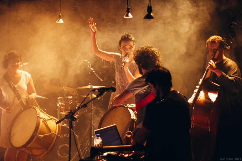 a band performing in a darkened room while musicians sing and play