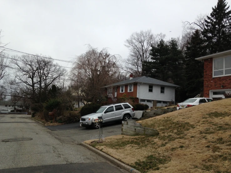 a couple of parked cars are in front of a house