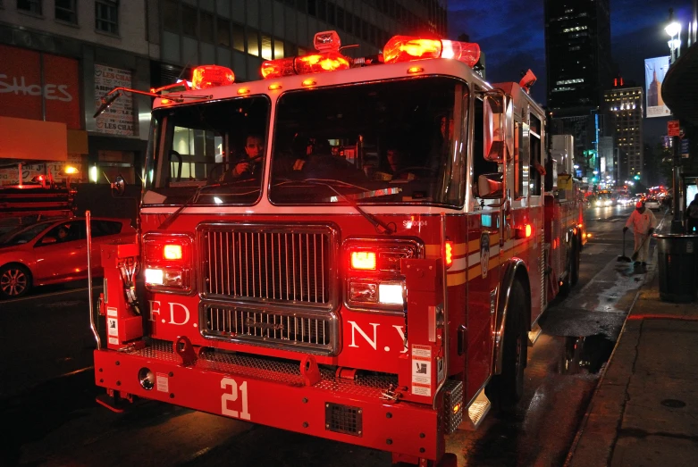 firetruck in roadway at night with city lights