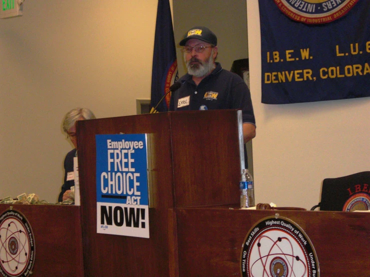 a man standing at a podium holding a free choice sign